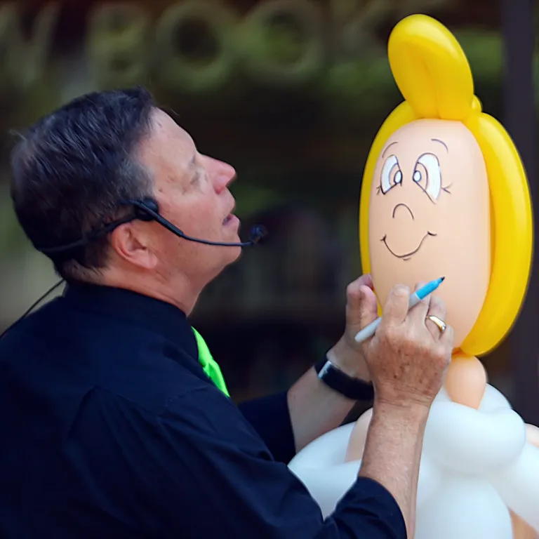 Dale Obrochta adding facial details to a large balloon character during The Art of Inflation show