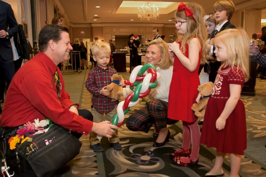 Dale Obrochta providing interactive balloon entertainment for families at a corporate holiday event in Chicago
